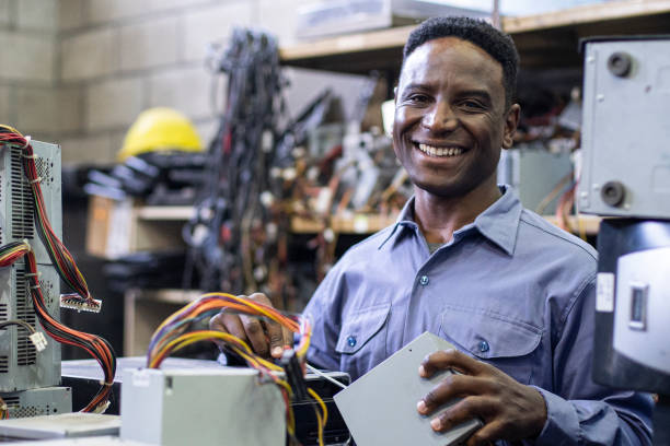 istock Smiling african american male e-waste recycling worker looking at the camera while holding computer components 1352363306