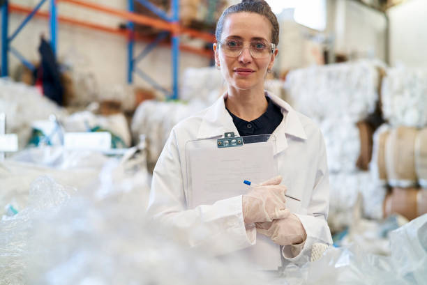 istock Smiling mid adult woman holding clipboard while standing inside recycling centre 1352364209