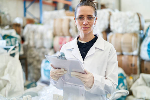 istock Smiling mid adult woman holding clipboard while standing inside recycling centre 1352364210