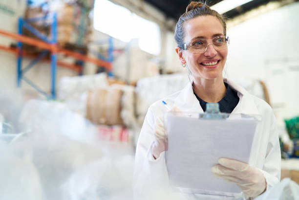 istock Smiling mid adult woman holding clipboard while standing inside recycling centre 1352364232