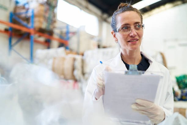 istock Smiling mid adult woman holding clipboard while standing inside recycling centre 1352364233