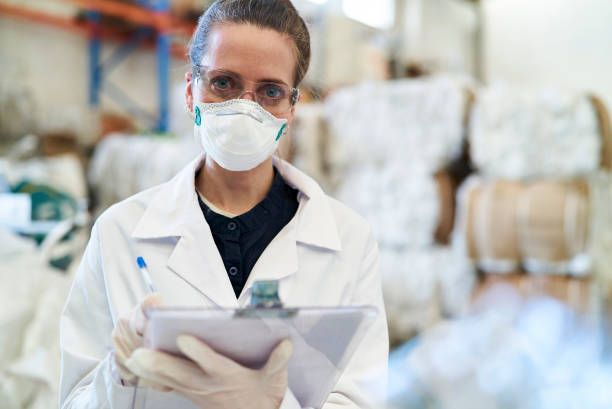istock Portrait of female techinician wearing protective facemask inside recycling centre 1352364257