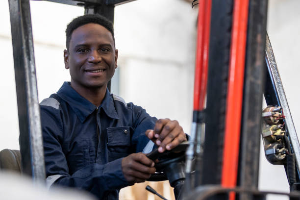 istock Portrait of smiling male worker sitting inside forklift control cabin 1352364829