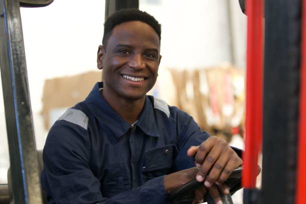 istock Portrait of smiling male worker sitting inside forklift control cabin 1352364832