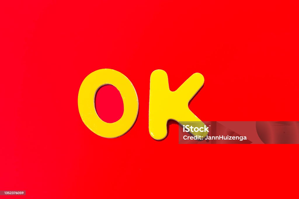 OK: Word Written in Toy Letters, Vibrant Red Background OK Sign Stock Photo