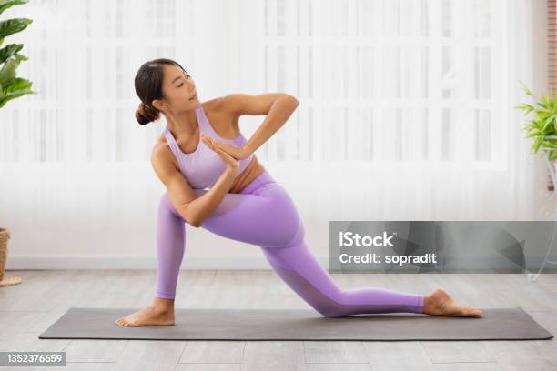 Individual Hatha Yoga Instructor Training Parivrtta Anjaneyasana Crescent Lunge On Knee Prayer Hands Modern By Asian Lady Trainer Stock Photo - Download Image Now