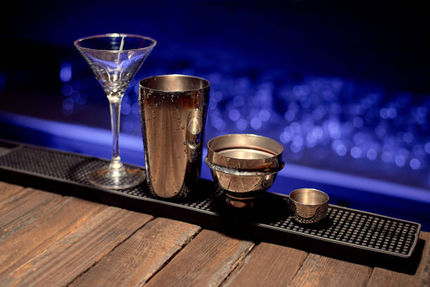 istock An empty cocktail glass stands on a bar counter with an iron shaker. 1352377583