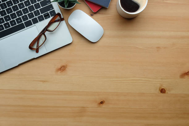 istock Top view laptop computer, glasses and coffee cup on wooden table. 1352380319