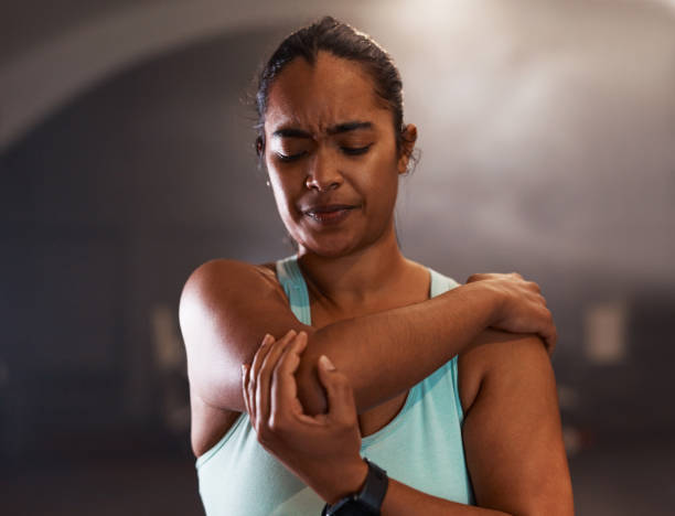 aufnahme einer jungen frau, die schmerzend beim training in einem fitnessstudio - ellenbogen stock-fotos und bilder