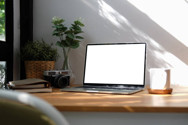 istock Comfortable workplace with computer laptop, supplies, coffee cup and potted plant on wood table. 1352381192