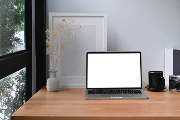 istock Computer laptop, books, coffee cup and picture frame on wooden table. 1352385610