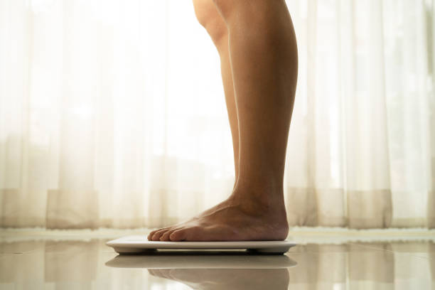 istock young woman standing on digital weight scale 1352389851
