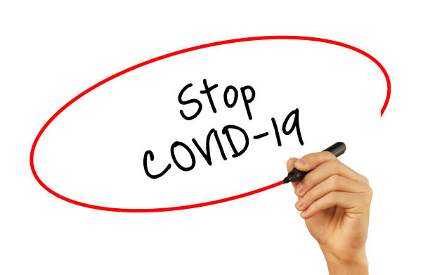 istock The hand writes text STOP COVID-19 with a marker on a white background 1352390746