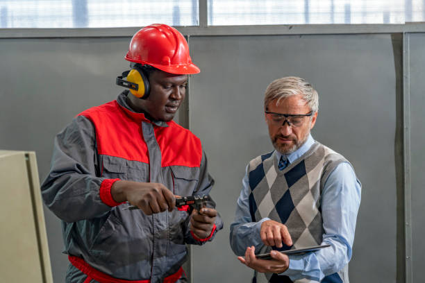 istock Quality Control Inspector Using Digital Tablet And Talking To African American CNC Machine Operator 1352392759