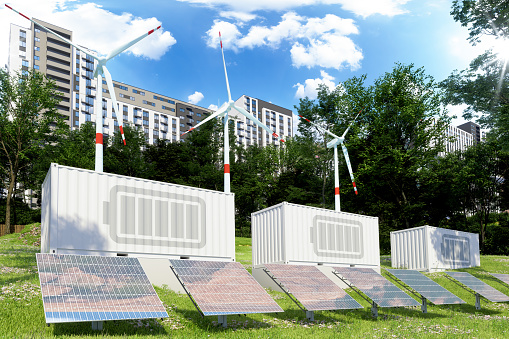 Sustainable Renewable Energy Concept With Wind Turbines, Solar Panels And City Buildings Background.