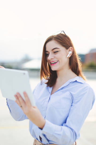 istock Redhead young businesswoman with tablet laughing outdoors 1352399607