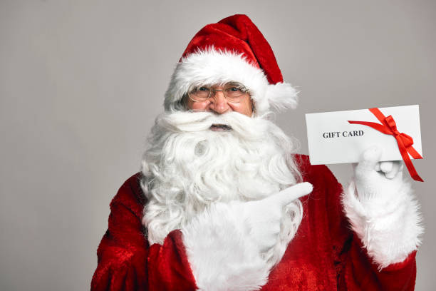 istock Santa Claus holding gift card in hands 1352402343