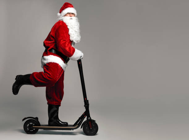 Santa Claus riding an electric scooter stock photo