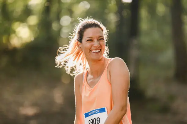 Happy female athlete enjoying before the marathon in nature. Copy space.