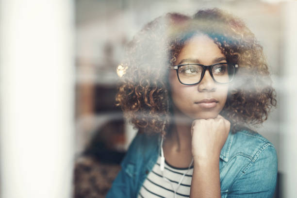 foto recortada de una atractiva joven que se ve pensativa y escucha música mientras está sentada en una cafetería - clear thinking fotografías e imágenes de stock