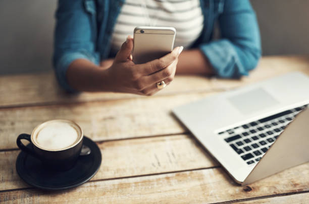 istock High angle shot of an unrecognizable woman using her cellphone while sitting in a coffee shop 1352406301