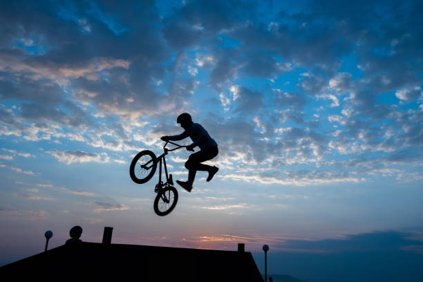 Silhouette of bicyclist against the background of the sky. stock photo