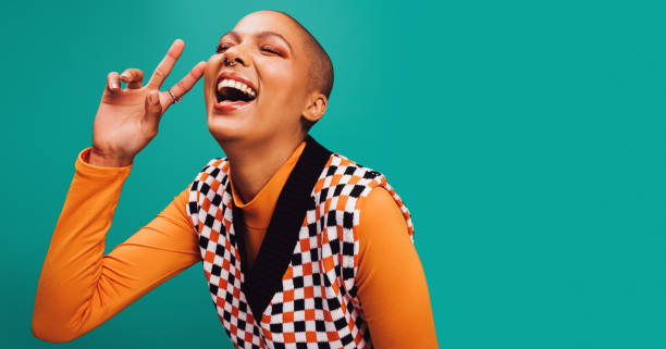 carefree young woman showing the peace sign in a studio - generatie z stockfoto's en -beelden