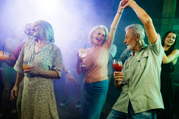 istock Happy mature couples dancing in a disco. 1352409838