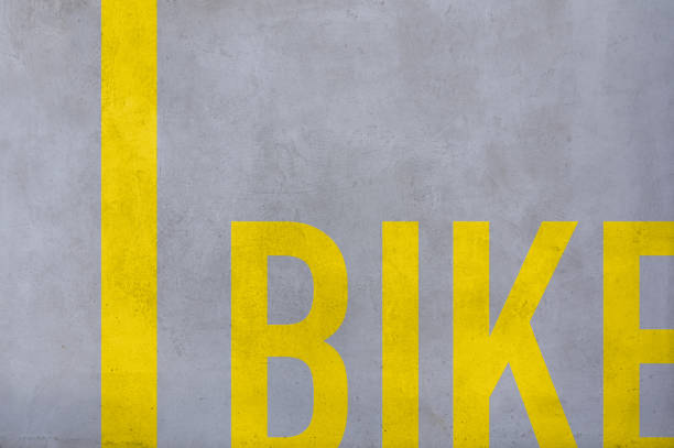 A painted bike lane sign on concrete road, abstract background.