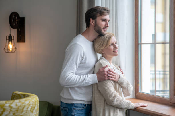 istock Mother and son standing near the window looking peaceful 1352410381