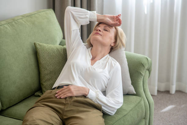 istock Blonde mid aged woman lying on the sofa and feeling bad 1352410425