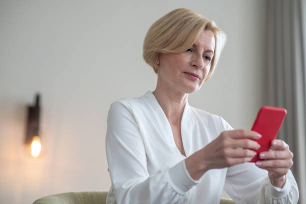 istock Blonde woman with a smartphone in hands 1352410446
