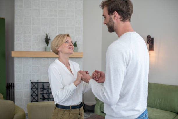 istock Man in white sweater holding his moms hands 1352410497