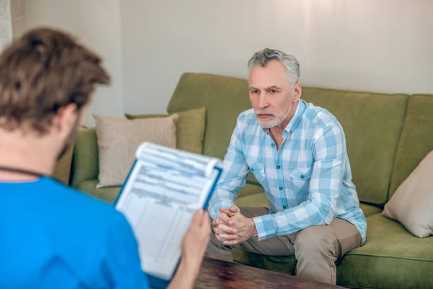 istock Male patient looking at a physician with a clipboard 1352410579