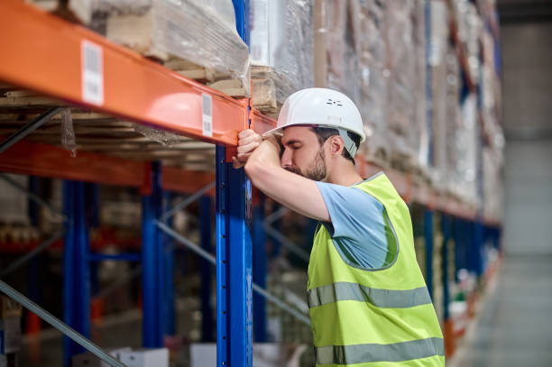 istock Man in overalls resting leaning against warehouse rack 1352413750