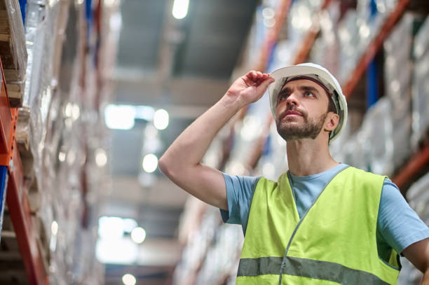 istock Man touching helmet on his head looking up 1352413751