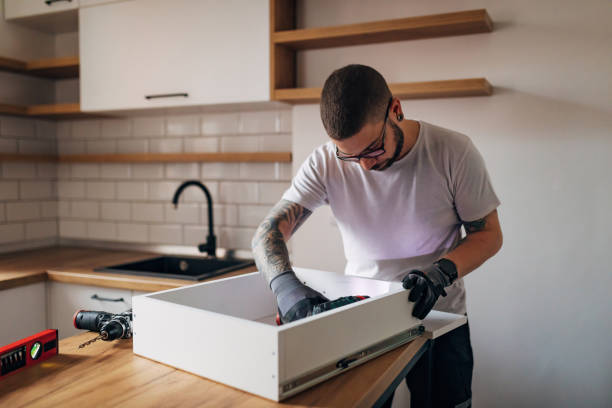 istock A serious craftsman is ready to work with an electric screwdriver and tools, assembles the furniture himself. 1352414716