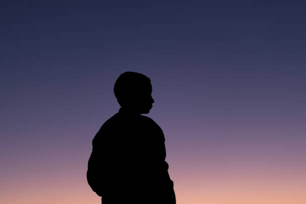 istock silhouette of a young boy during sunset 1352414850