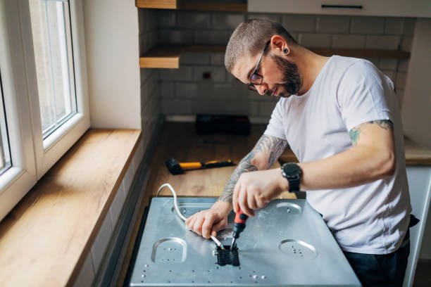 istock A tattooed worker fixes the stove with a screwdriver. He is in the kitchen. 1352415025