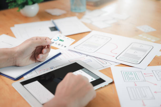istock UX or UI designers designing on digital tablet and smartphone application layout prototype project. 1352415381