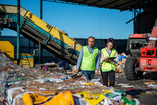 A high-tech recycling facility where paper, cardboard and plastic wastes are collected and sorted. Environmental engineers working at the facility