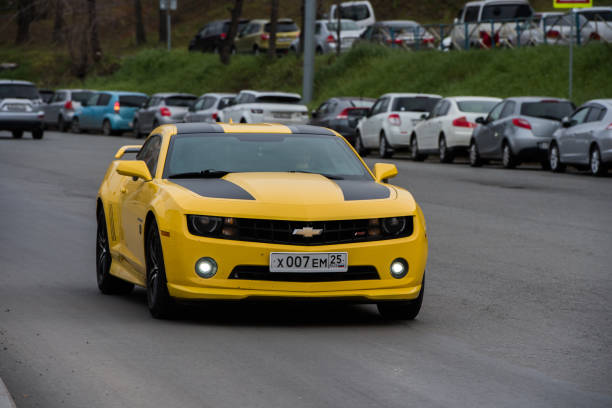 Chevrolet Camaro  is driving down the city street. stock photo