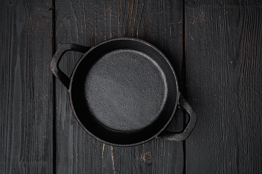 Black cooking pot set with copy space for text or food with copy space for text or food, top view flat lay, on black wooden table background