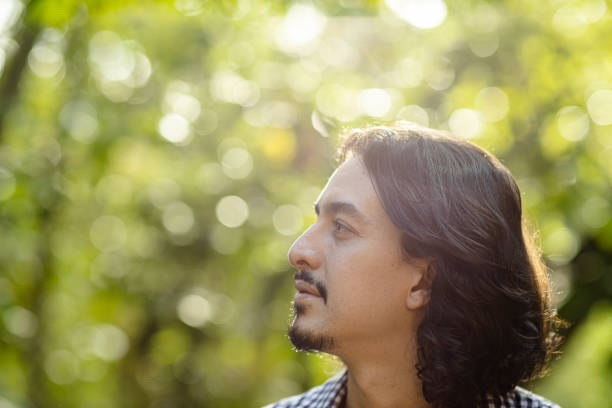 istock Portrait of man among trees in forest 1352416787