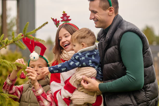 istock Smiling people decorating a christmas tree 1352418869