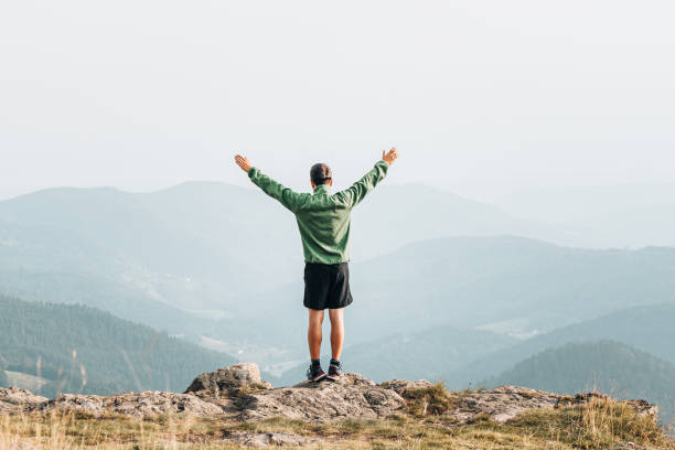 istock Hiker relaxes at viewpoint on grassy mountain ridge 1352420072