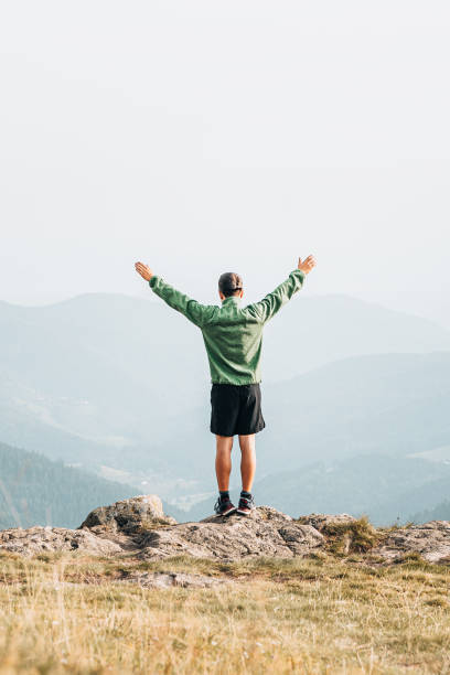 istock Hiker relaxes at viewpoint on grassy mountain ridge 1352420074