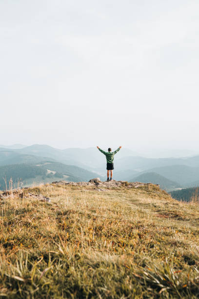 istock View of hiker relaxing on grassy mountain ridge 1352420078
