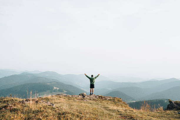 istock View of hiker relaxing on grassy mountain ridge 1352420092