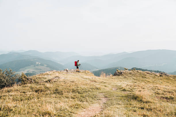 istock View of hiker relaxing on grassy mountain ridge 1352420145